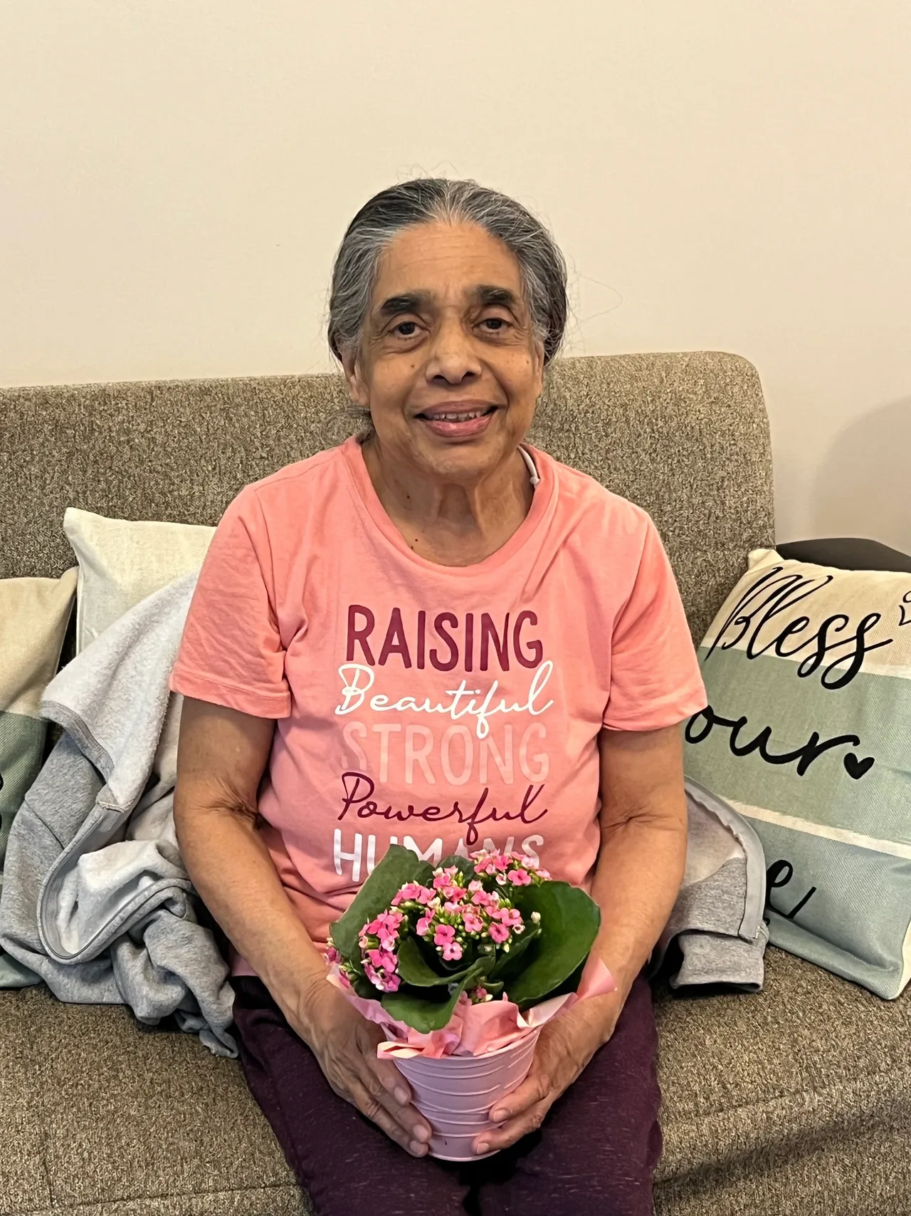 Senior seated on couch with cushions